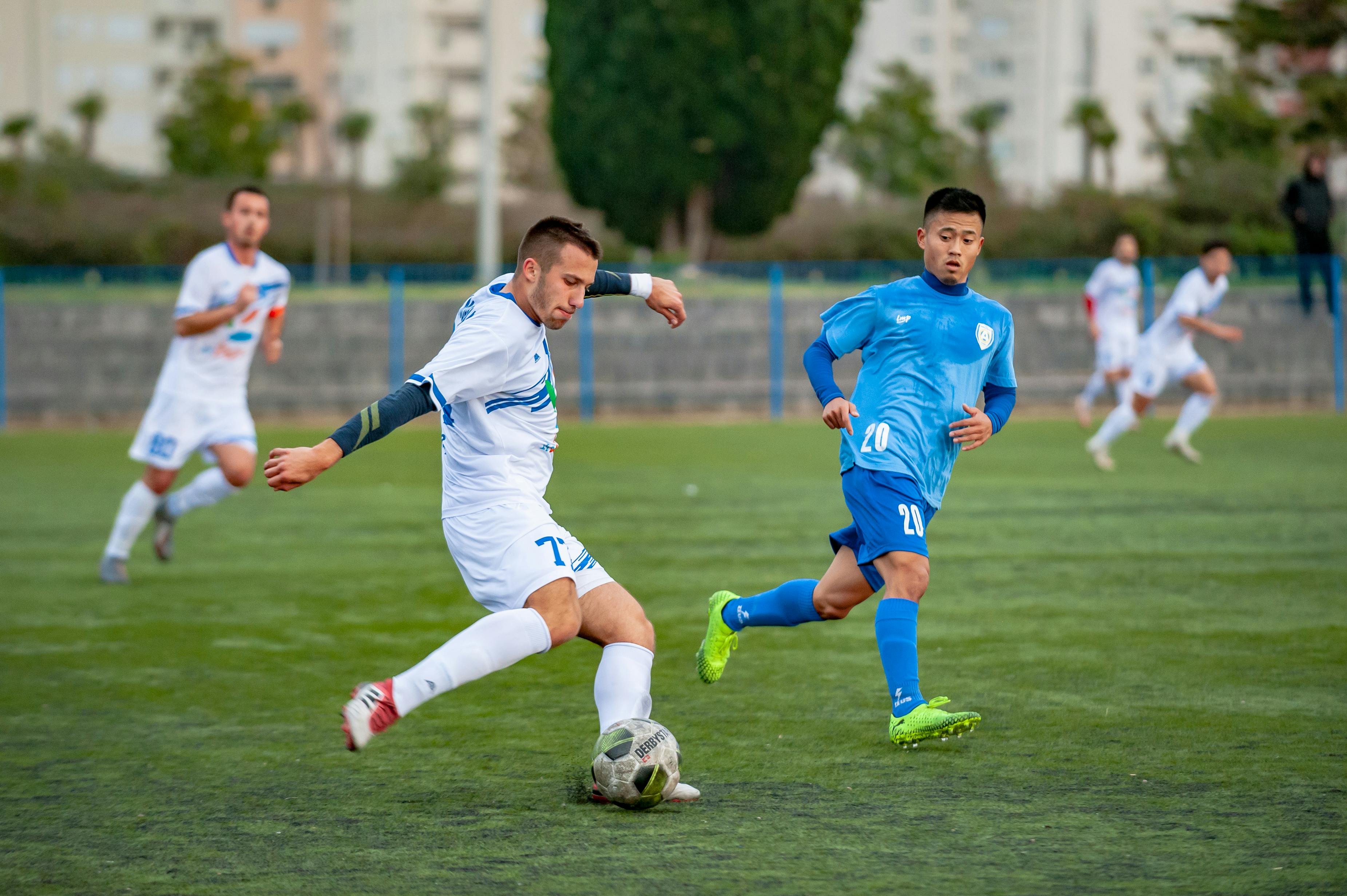 Football players moving across a green pitch